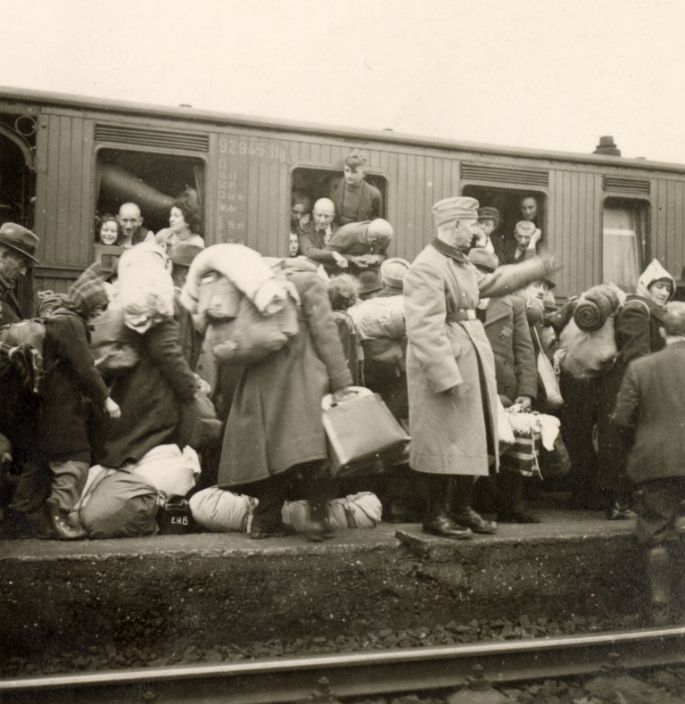 Zustieg der Jüdinnen und Juden aus Bielefeld, dem Regierungsbezirk Minden und Lippe in den Deportationszug nach Riga am 13. Dezember 1941. In der Kriegschronik ist das Bild unterschieben mit: „Mal ein bisschen dalli! Einsteigen! Einsteigen!“.